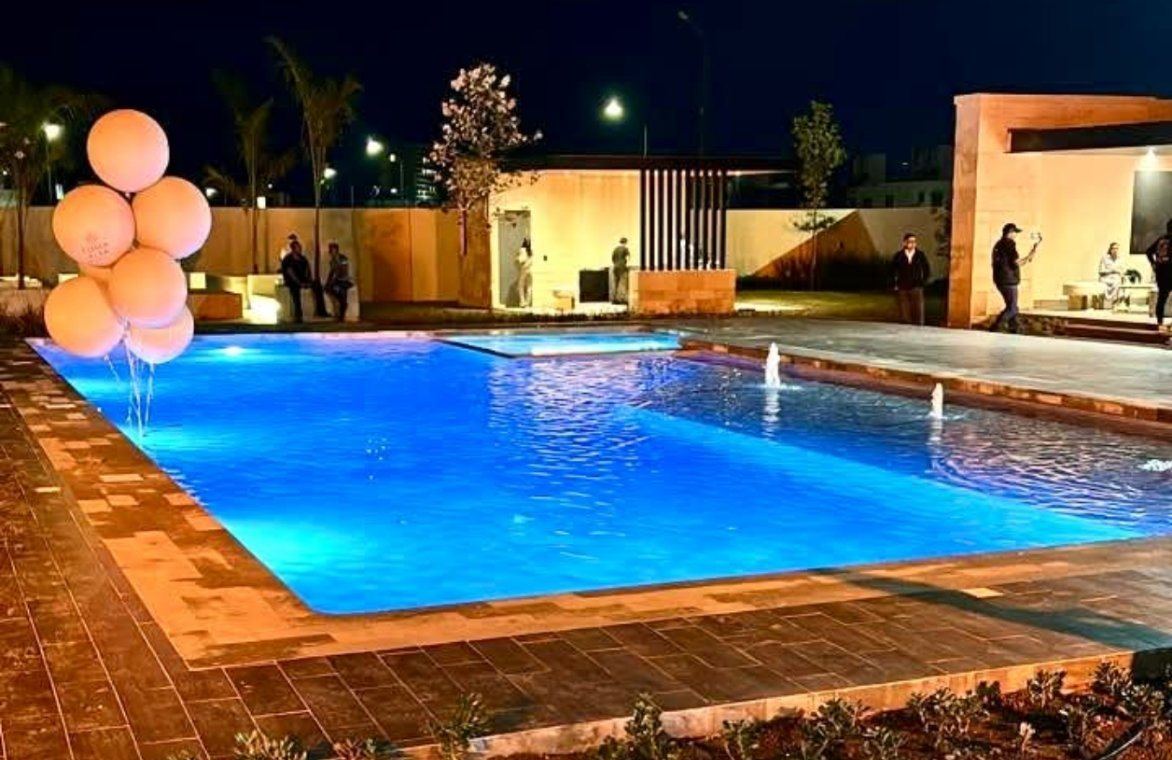 Alberca iluminada de noche con fuentes